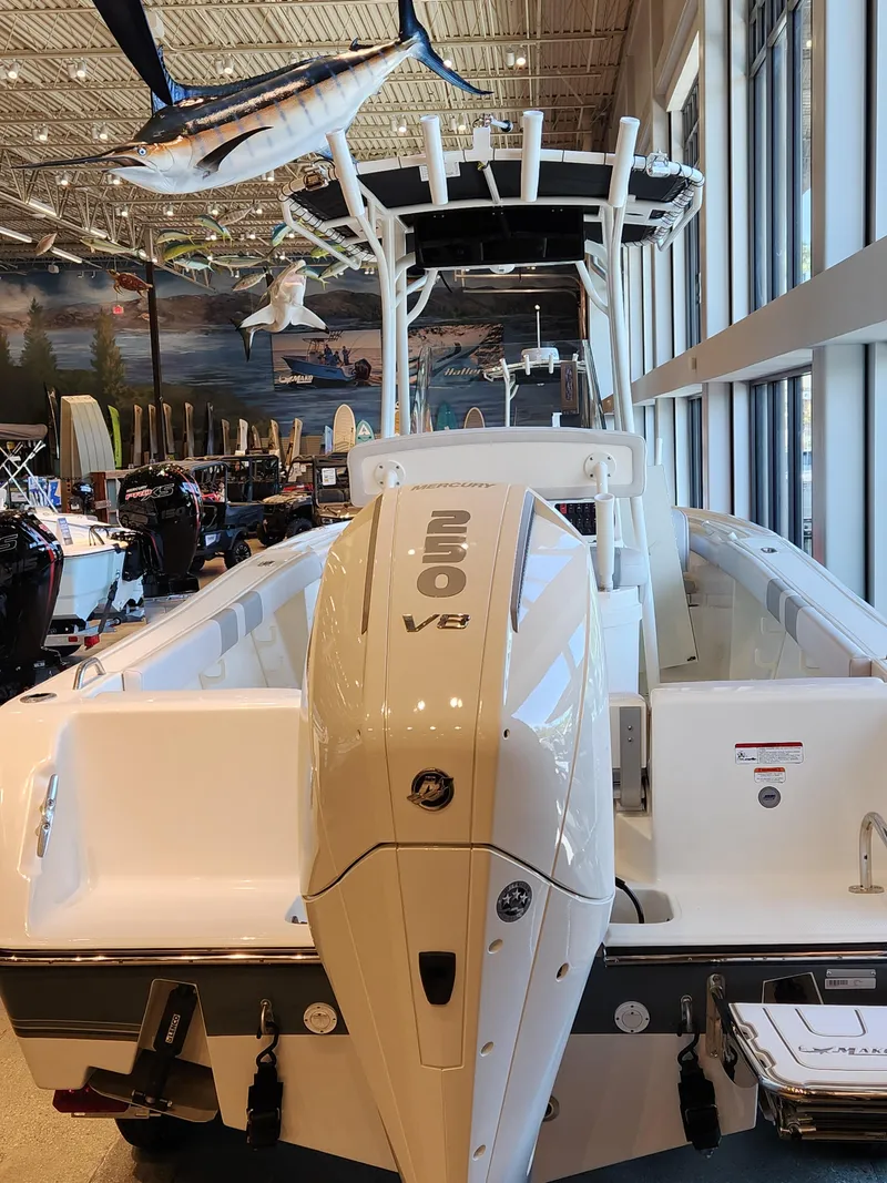 Slide: The Image of 2025 Mako 214 CC boat with powerful V8 engine displayed indoors. - 5
