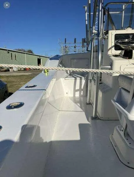 Slide: The Image of 1995 Custom 24 OPEN boat deck with seating and railing, under clear blue sky. - 10