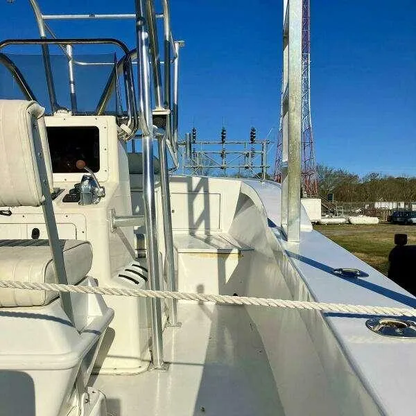 Slide: The Image of Custom 24 OPEN boat, 1995 model, with white seating and metal railings under clear blue sky. - 11