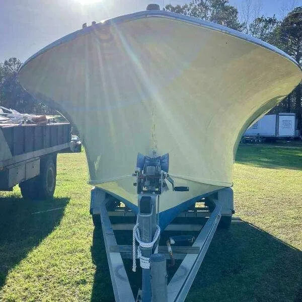 Slide: The Image of Custom 1995 24 OPEN boat on trailer, sunlit, parked on grass. - 2