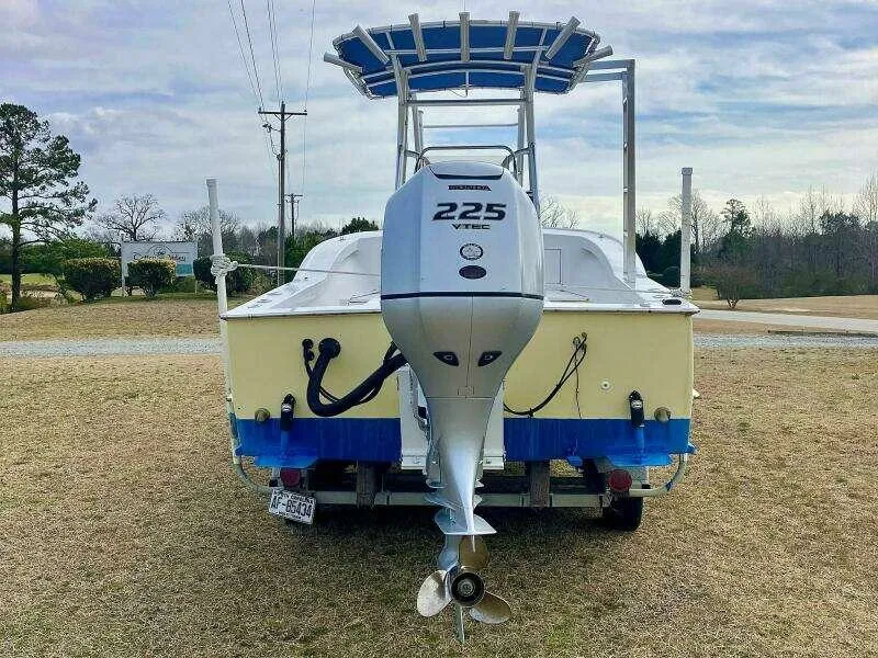 Slide: The Image of Custom 24 OPEN 1995 boat with Honda 225 outboard motor, parked on grass. - 4