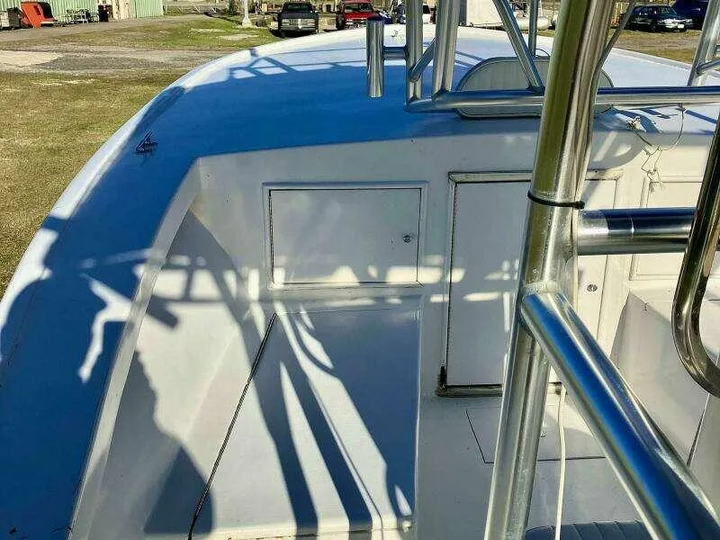 Slide: The Image of 1995 Custom 24 OPEN boat deck with stainless steel railings and storage compartments. - 6
