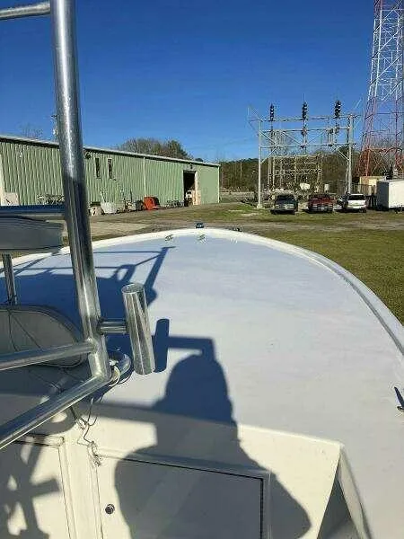 Slide: The Image of Custom 24 OPEN boat, 1995 model, docked near industrial buildings and power lines. - 7