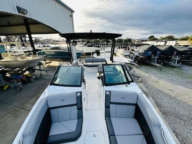 Slide: The Image of 2022 Cobalt R8 boat with sleek design, docked at a marina under cloudy skies. - 22