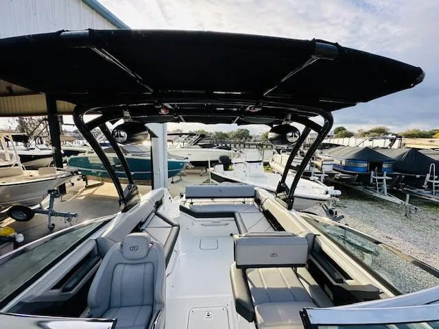 Slide: The Image of 2022 Cobalt R8 boat with spacious seating and sleek design at a marina. - 23