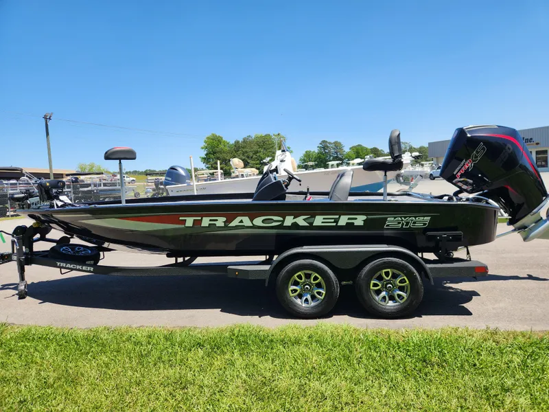 Slide: The Image of 2025 Tracker Savage 215 boat on trailer, parked outdoors on a sunny day. - 7
