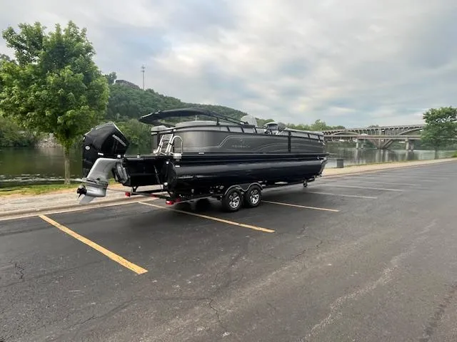 Slide: The Image of 2024 Regency 250LE3 pontoon boat on trailer by riverside parking lot. - 4