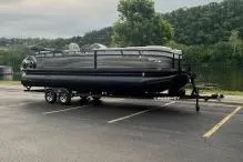 Slide: The Image of 2024 Regency 250LE3 pontoon boat on trailer in parking lot near lake. - 7