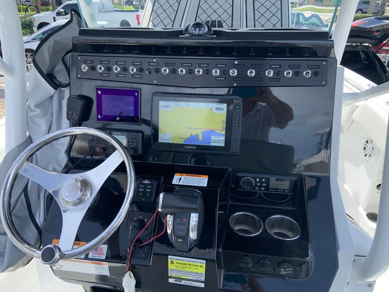 Slide: The Image of 2020 Wellcraft 222F boat dashboard with steering wheel, navigation screens, and control panel. - 10