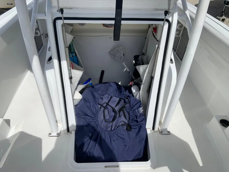 Slide: The Image of 2020 Wellcraft 222F boat storage compartment with gear and equipment inside. - 11