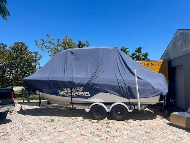 Slide: The Image of 2020 Wellcraft 222F boat covered on trailer, parked outdoors. - 3