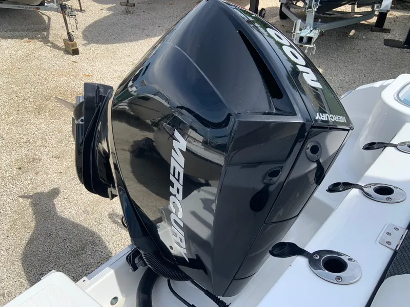 Slide: The Image of Mercury outboard motor on a 2020 Wellcraft 222F boat, parked on gravel. - 4
