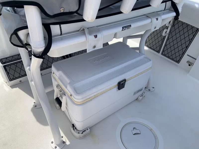 Slide: The Image of 2020 Wellcraft 222F boat deck with a secured white cooler and storage nets. - 6