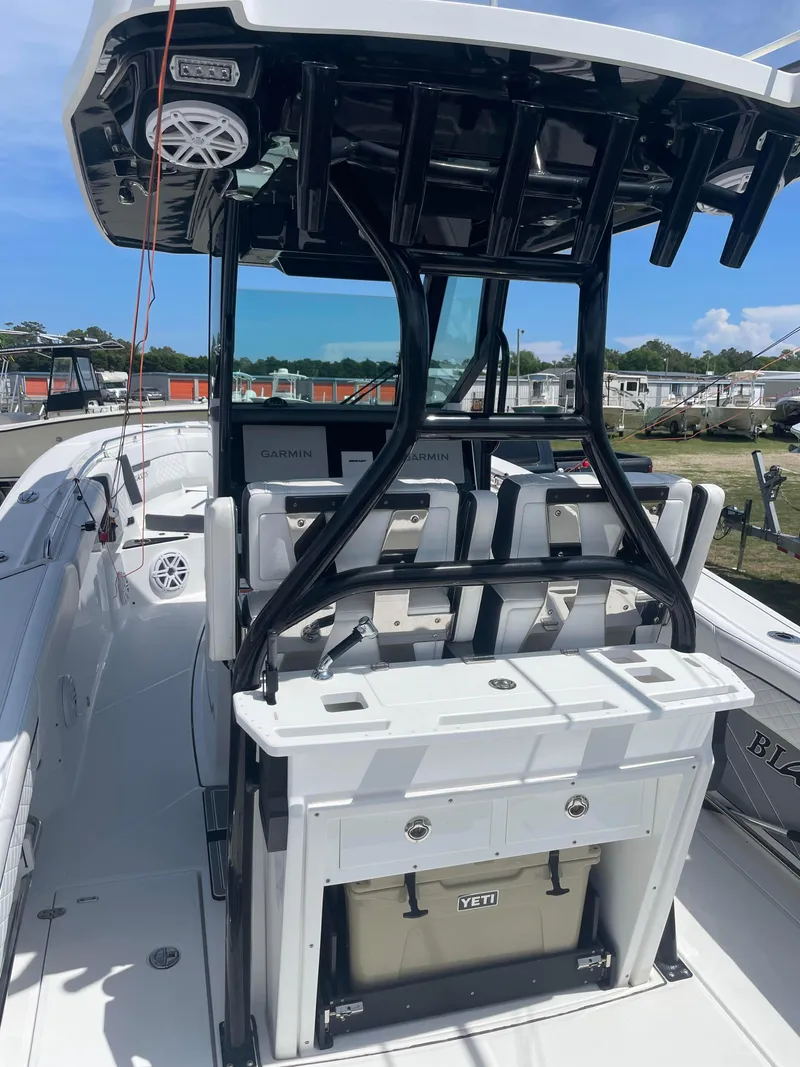 Slide: The Image of 2022 Blackfin 272 CC boat interior with seating and storage, docked under clear skies. - 5