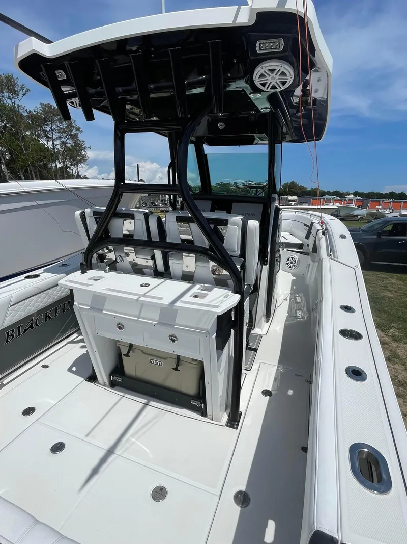 Slide: The Image of 2022 Blackfin 272 CC boat with sleek design and modern features, docked outdoors. - 6