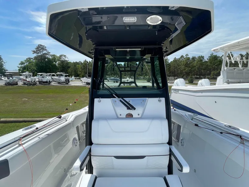 Slide: The Image of 2022 Blackfin 272 CC boat interior with seating and console, displayed outdoors. - 9