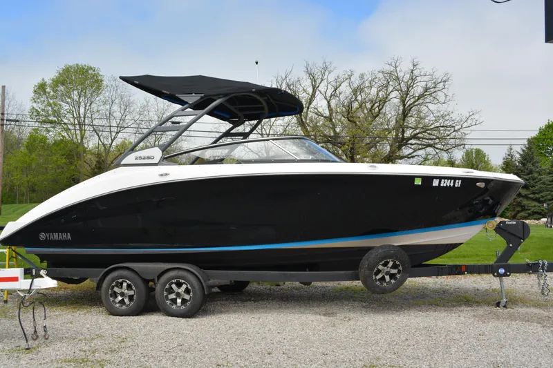 Slide: The Image of 2021 Yamaha Boats 252SD on trailer, black hull, outdoor setting. - 1