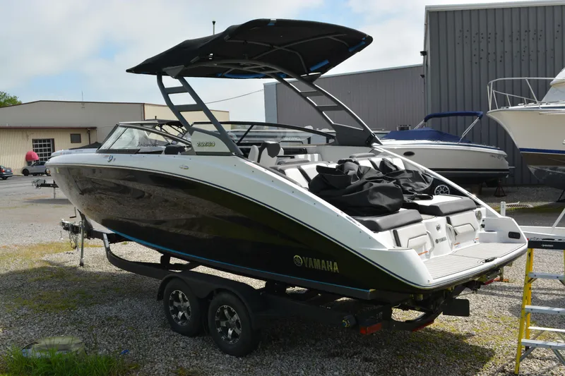 Slide: The Image of 2021 Yamaha Boats 252SD on trailer, black and white design, parked outdoors. - 4