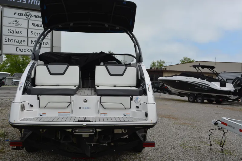 Slide: The Image of 2021 Yamaha Boats 252SD, rear view, in a marina setting with other boats. - 6