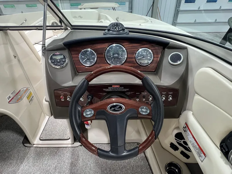 Slide: The Image of 2008 Sea Ray 230 Select boat dashboard with wood accents and steering wheel. - 10