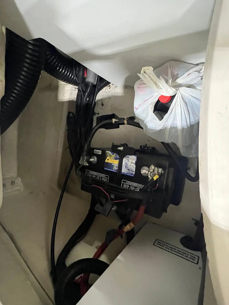 Slide: The Image of 2008 Sea Ray 230 Select boat battery compartment with wiring and storage bag. - 18