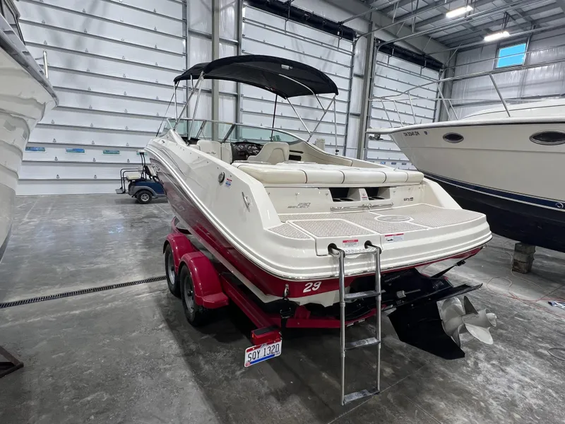 Slide: The Image of 2008 Sea Ray 230 Select boat in storage, featuring red trailer and black canopy. - 4