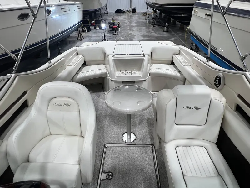 Slide: The Image of 2008 Sea Ray 230 Select boat interior with white seating and table in showroom. - 7