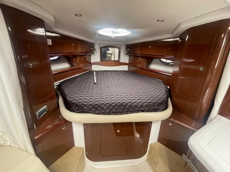 Slide: The Image of Luxurious 2014 Four Winns Vista 375 cabin interior with elegant wood finish and cozy bedding. - 11