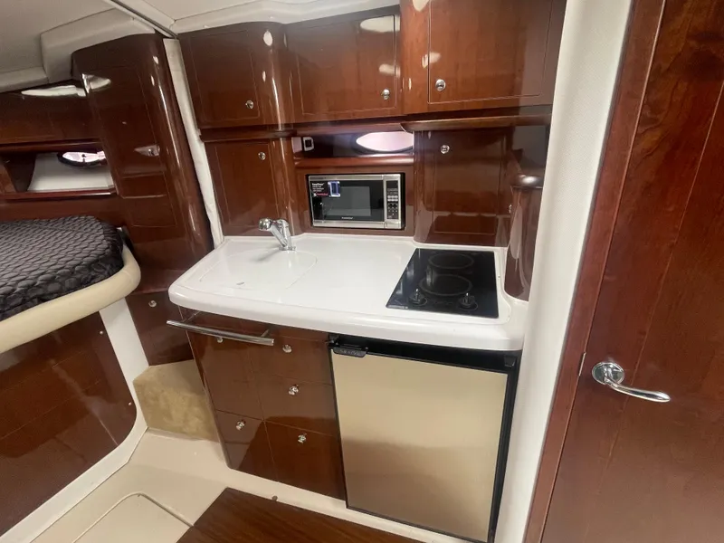 Slide: The Image of 2014 Four Winns Vista 375 yacht interior kitchen with microwave, sink, stove, and fridge. - 16
