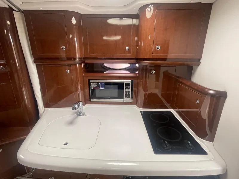 Slide: The Image of 2014 Four Winns Vista 375 yacht kitchen with microwave, sink, and stove. - 17