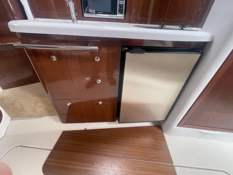 Slide: The Image of 2014 Four Winns Vista 375 yacht kitchen with wood cabinets and stainless steel fridge. - 18