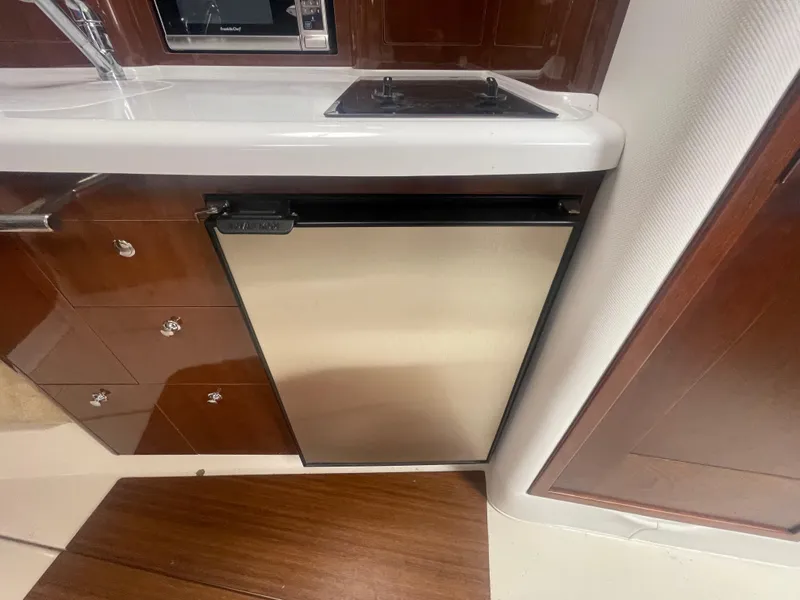 Slide: The Image of 2014 Four Winns Vista 375 yacht interior with compact kitchen and stainless steel fridge. - 19