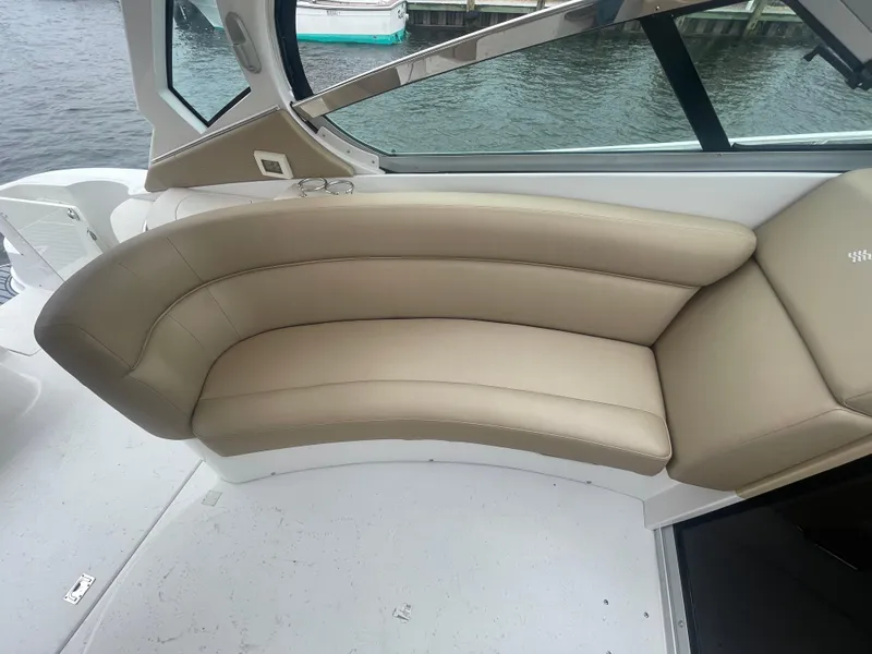Slide: The Image of 2014 Four Winns Vista 375 boat interior with beige leather seating by the water. - 34