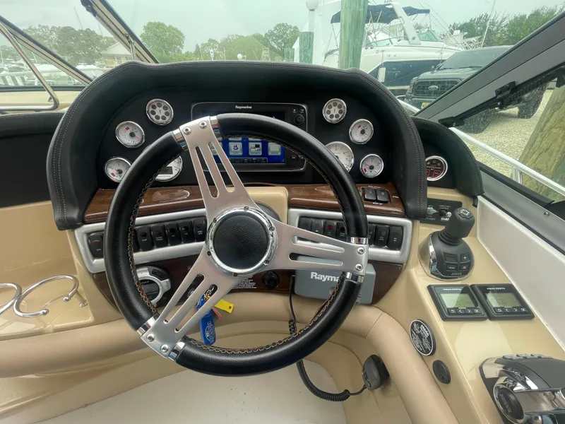 Slide: The Image of Steering wheel and dashboard of 2014 Four Winns Vista 375 boat, featuring modern controls and gauges. - 35