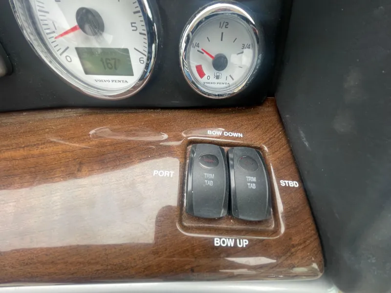 Slide: The Image of Control panel of a 2014 Four Winns Vista 375 boat with trim tab switches. - 43