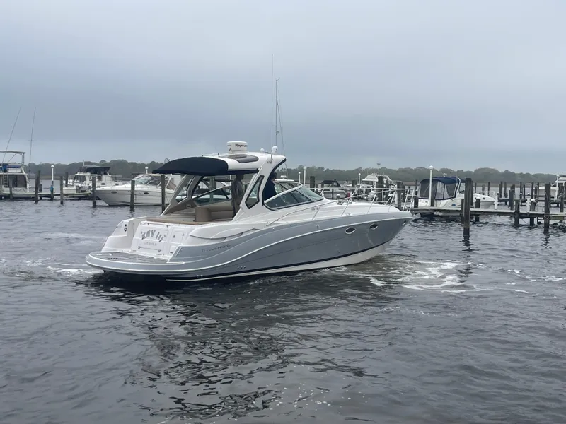 Slide: The Image of 2014 Four Winns Vista 375 boat cruising in a marina under cloudy skies. - 7