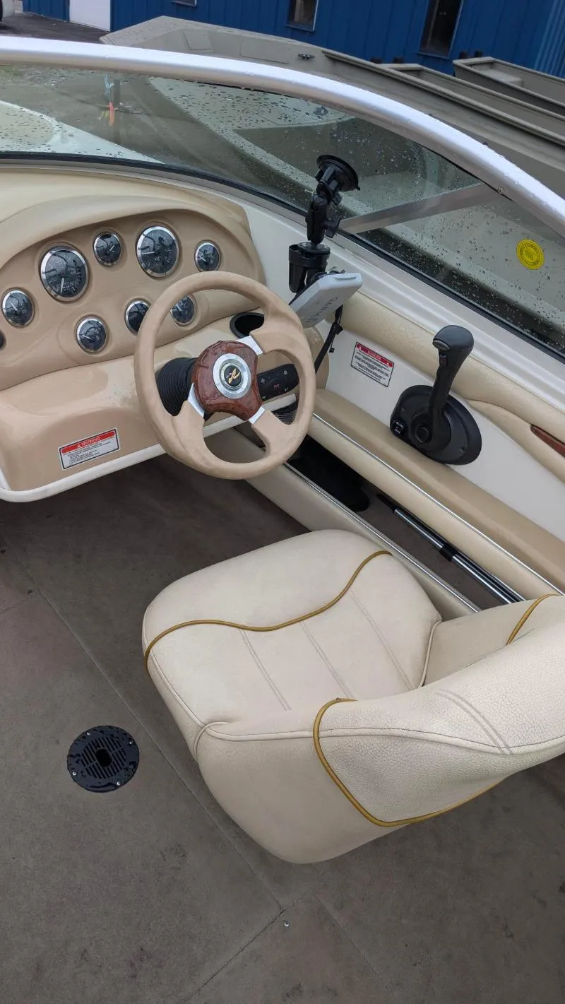Slide: The Image of 2001 Sea Ray 185 Sport Boat interior with beige seating and dashboard controls. - 13