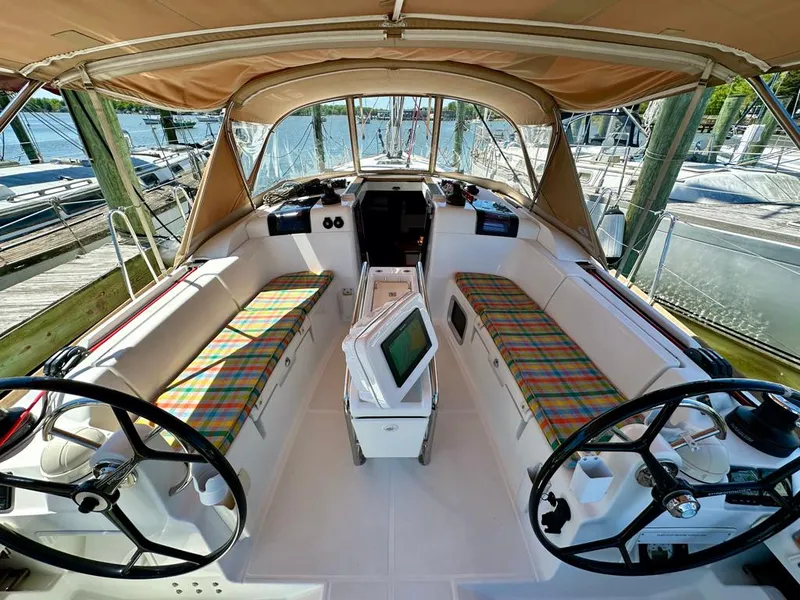 Slide: The Image of 2018 Jeanneau Sun Odyssey 419 sailboat cockpit with dual steering wheels and plaid seating. - 10