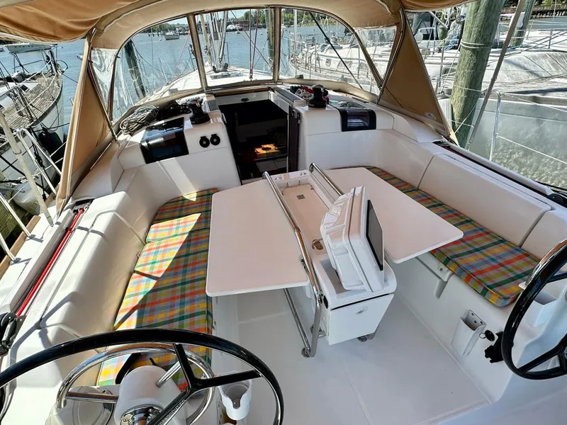 Slide: The Image of 2018 Jeanneau Sun Odyssey 419 cockpit with plaid seating and dual steering wheels. - 11