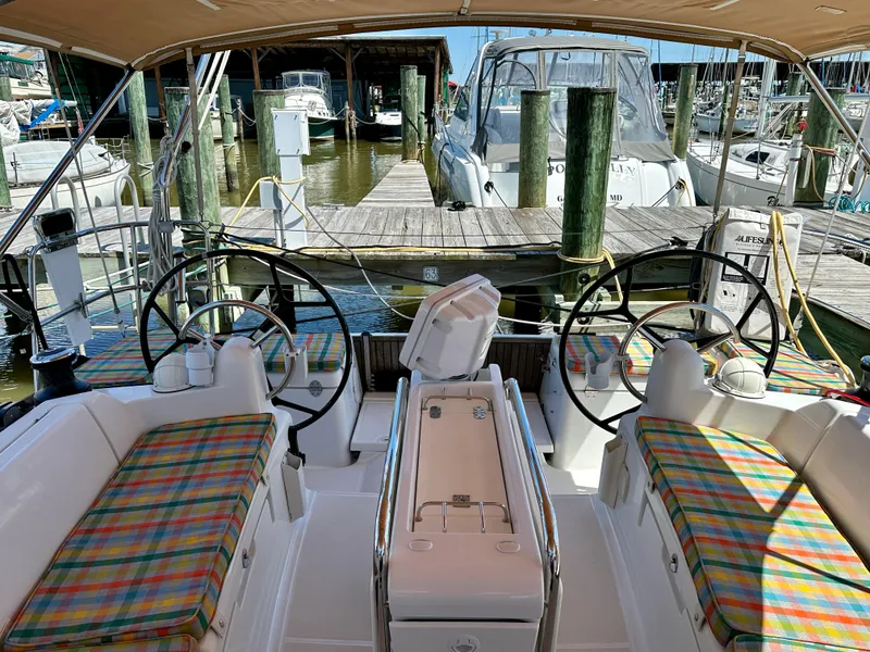 Slide: The Image of 2018 Jeanneau Sun Odyssey 419 sailboat cockpit with dual steering wheels and colorful seating. - 12
