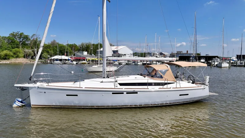 Slide: The Image of 2018 Jeanneau Sun Odyssey 419 sailboat docked in a marina under clear blue skies. - 2