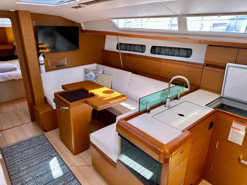 Slide: The Image of 2018 Jeanneau Sun Odyssey 419 interior with modern kitchen, seating area, and TV. - 31