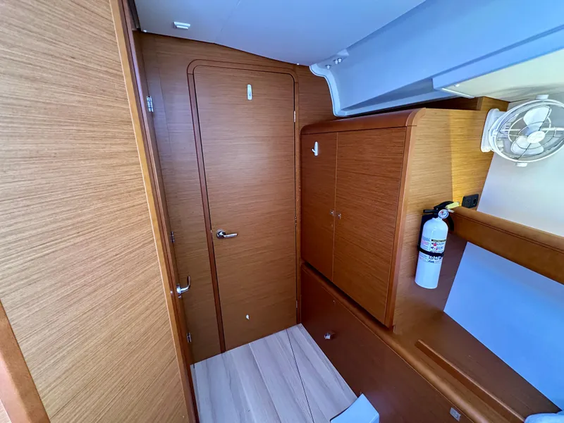 Slide: The Image of Interior of 2018 Jeanneau Sun Odyssey 419 yacht, featuring wooden cabinetry and a fire extinguisher. - 45