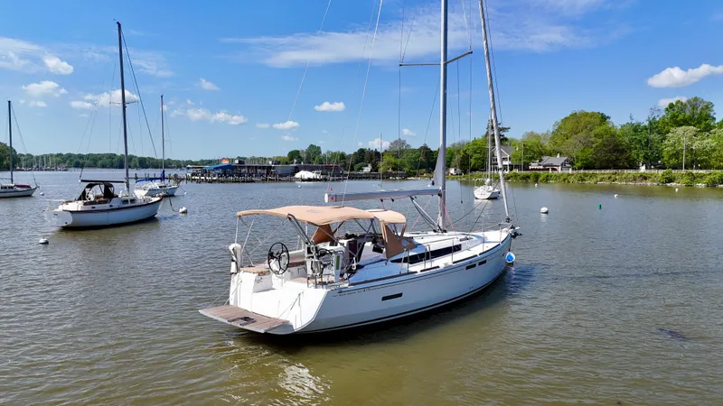 Slide: The Image of 2018 Jeanneau Sun Odyssey 419 sailboat anchored in a serene harbor. - 6