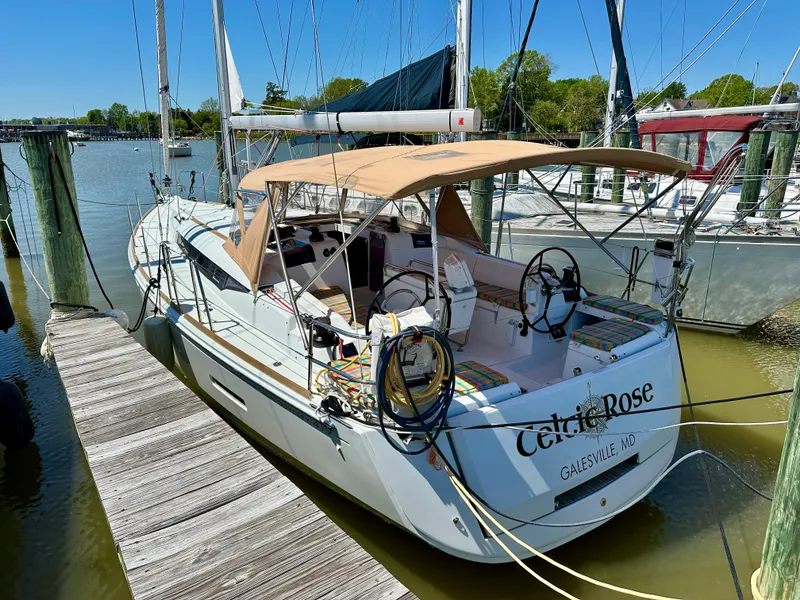 Slide: The Image of 2018 Jeanneau Sun Odyssey 419 sailboat docked, featuring a tan canopy and dual steering wheels. - 7