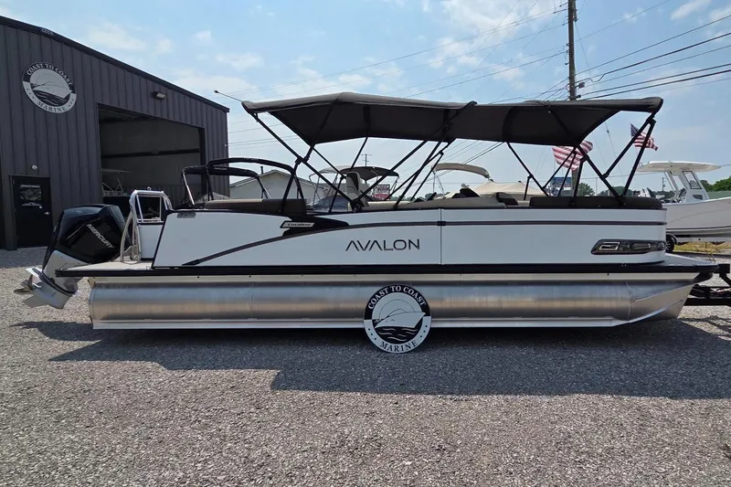 Slide: The Image of 2025 Avalon Platinum Catalina 2385 Elite pontoon boat parked outdoors. - 2