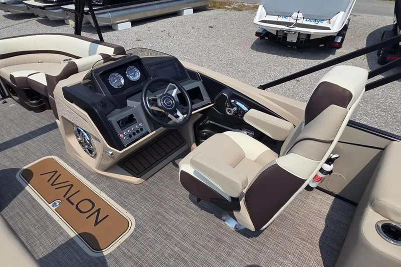 Slide: The Image of 2025 Avalon Platinum Catalina 2385 Elite boat interior with steering console and seating. - 8