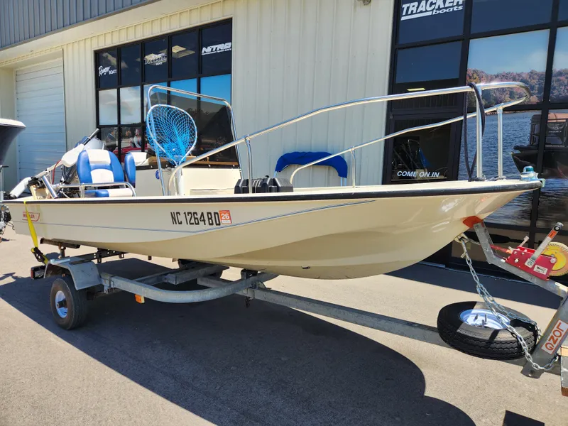 Slide: The Image of 1985 Boston Whaler 15 boat on trailer, parked outside a building. - 1