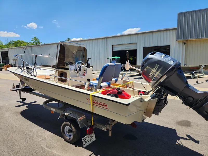 Slide: The Image of 1985 Boston Whaler 15 boat on trailer, parked outdoors, with Yamaha outboard motor. - 3