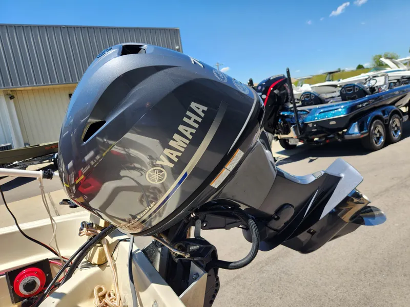 Slide: The Image of 1985 Boston Whaler 15 with Yamaha outboard motor, parked outdoors under clear sky. - 5